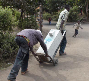 worker pushing a cart with a sand filter